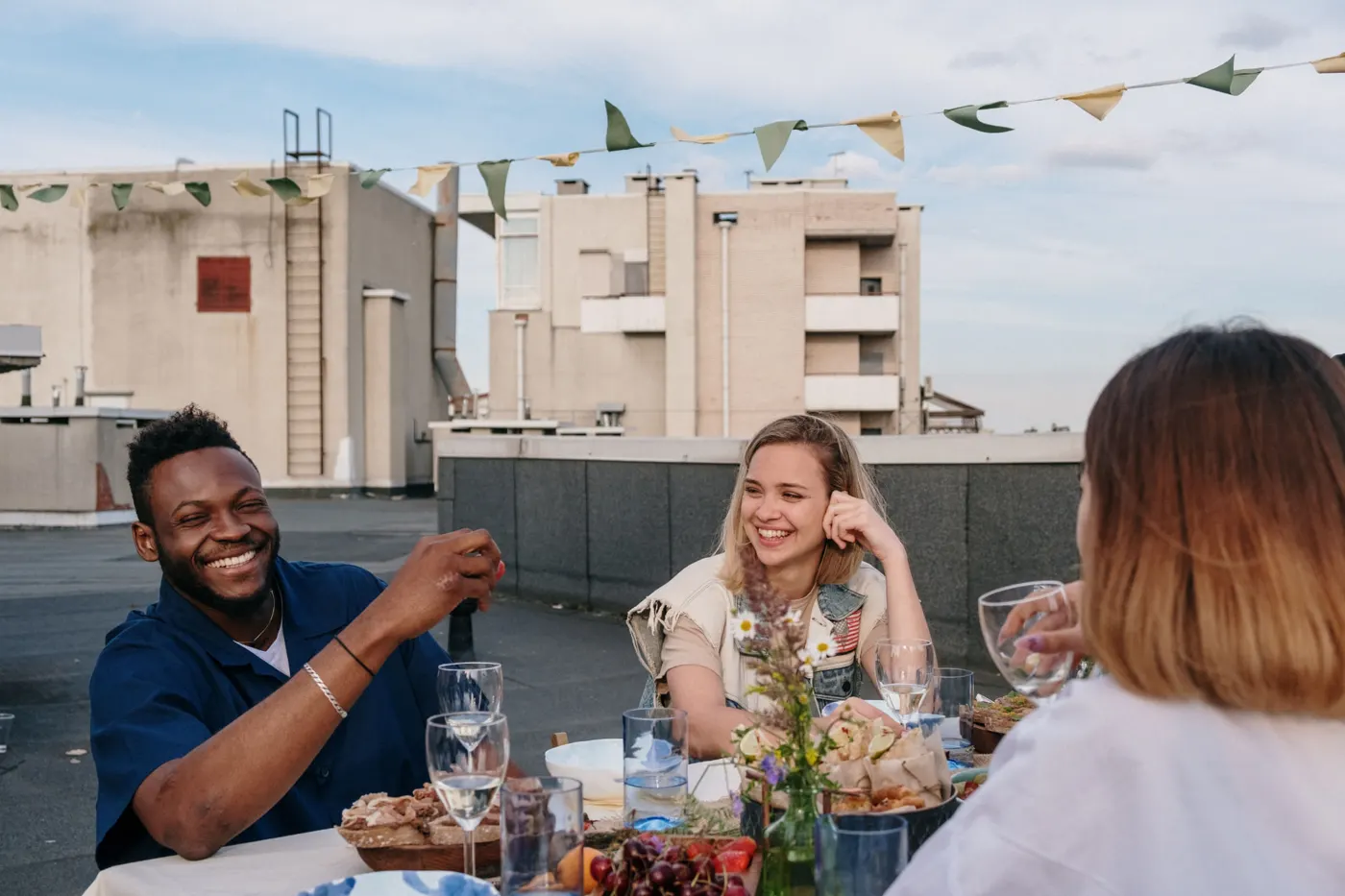Friends laughing together at a rooftop dinner