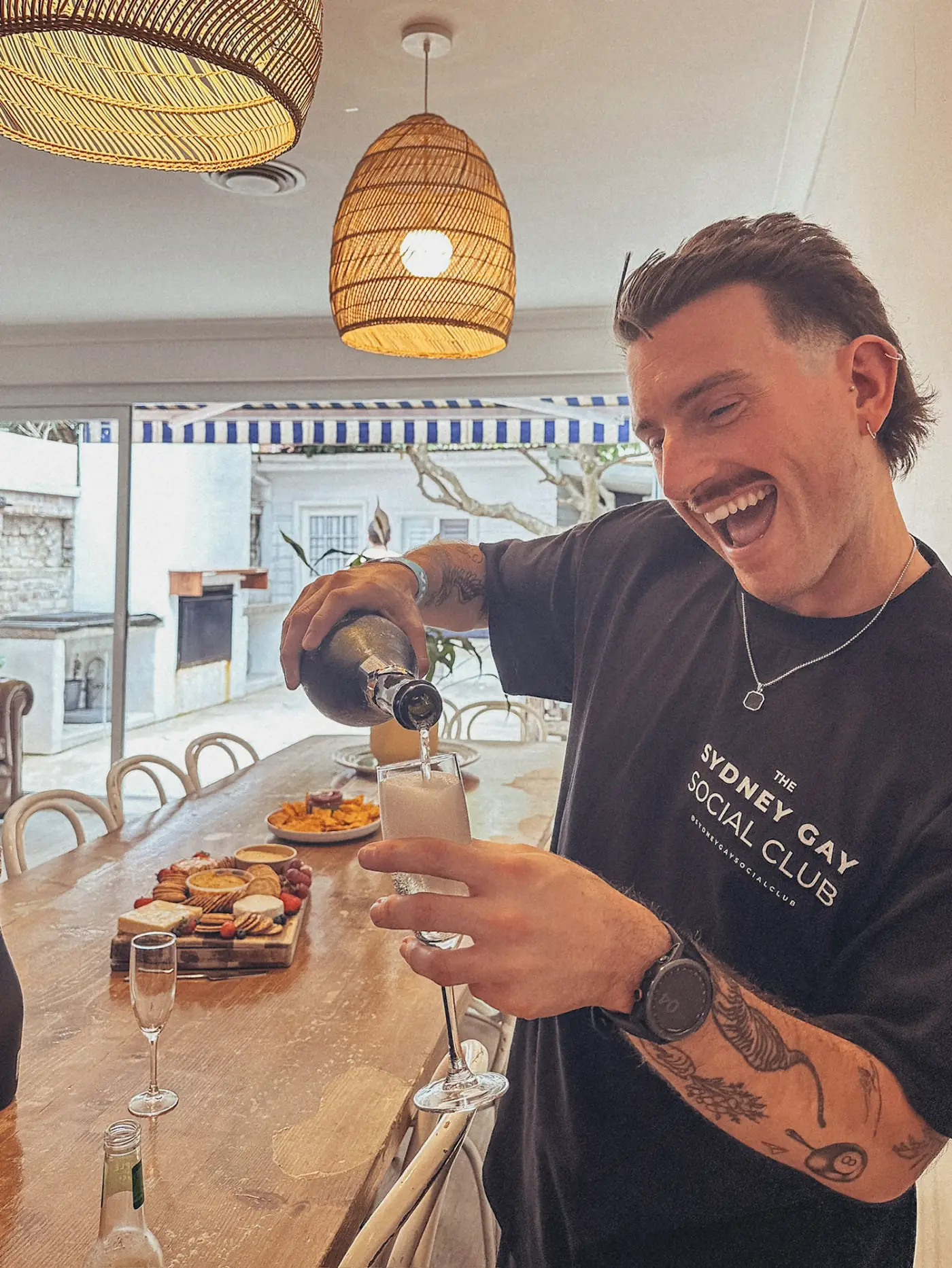 A Gay Social Club host pouring drinks and welcoming members